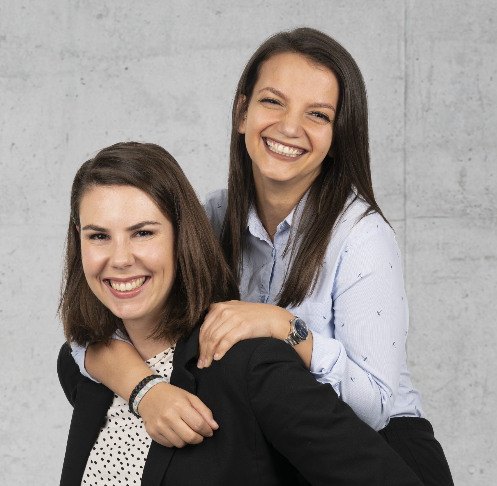 Hyrije ist auf den Rücken von Julia drauf. Sie beide lachen in der Kamera.